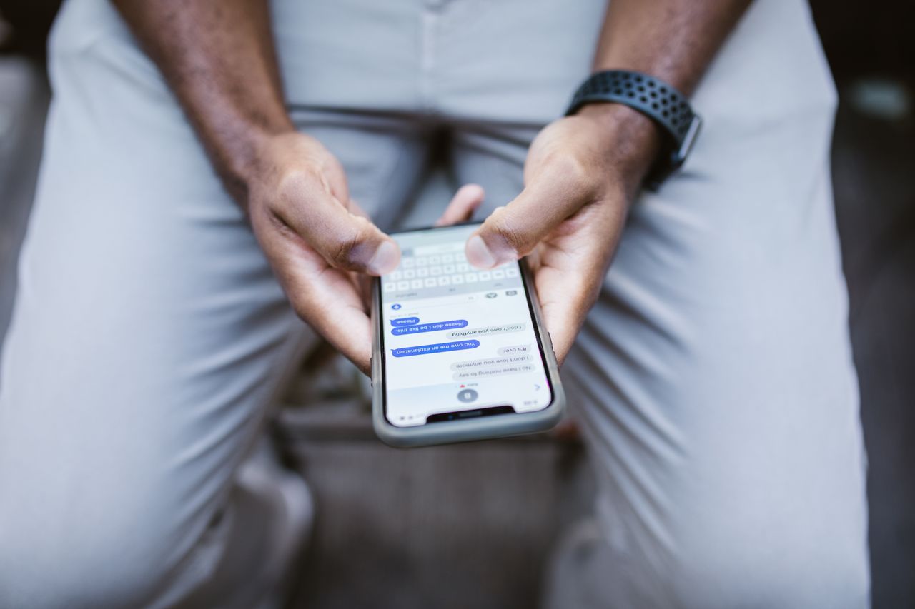 Close-up view of a man texting on a smartphone, capturing communication in action.